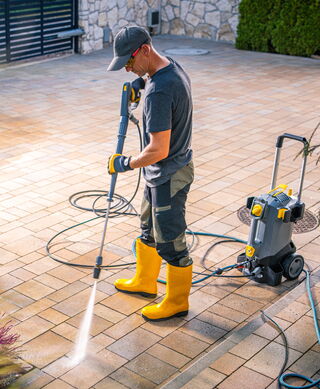Gebäudereinigung - Arbeiter beim Terrasse abdampfen
